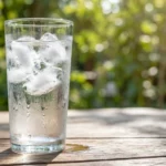 Varannan vatten ett-glas-kallt-vatten-med-is-pa-ett-trabord-utomhus
